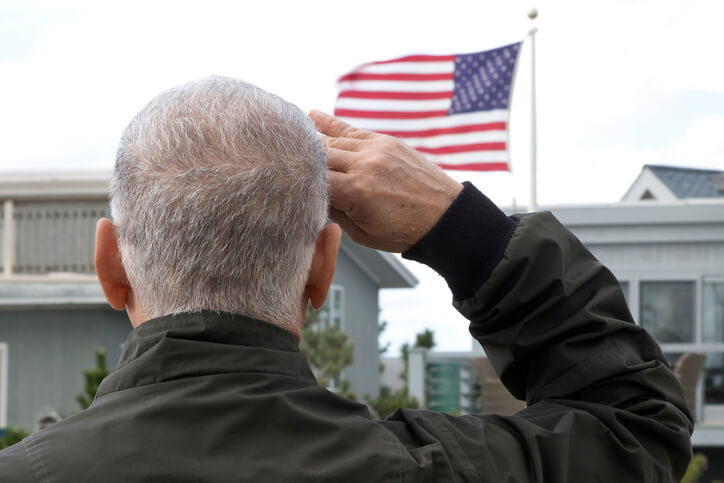 A U.S. military veteran salutes an American flag