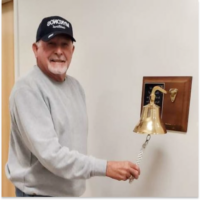 John, a mesothelioma survivor, ringing a gold bell